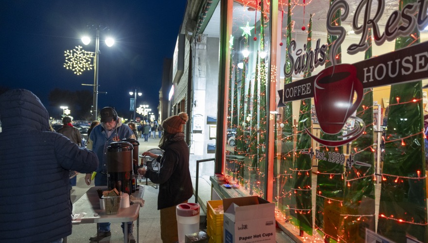 The brightly lit, cheerful exterior of Saints Rest Coffee House downtown during Jingle Bell Holiday.