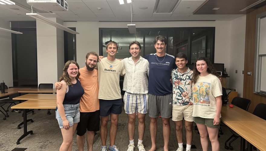 James poses with a group of friends in a classroom