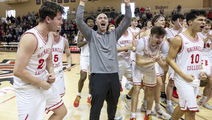 Men's basketball team and the coach cheers after winning 