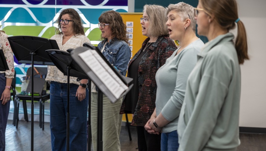 women singing at practice with music stands 