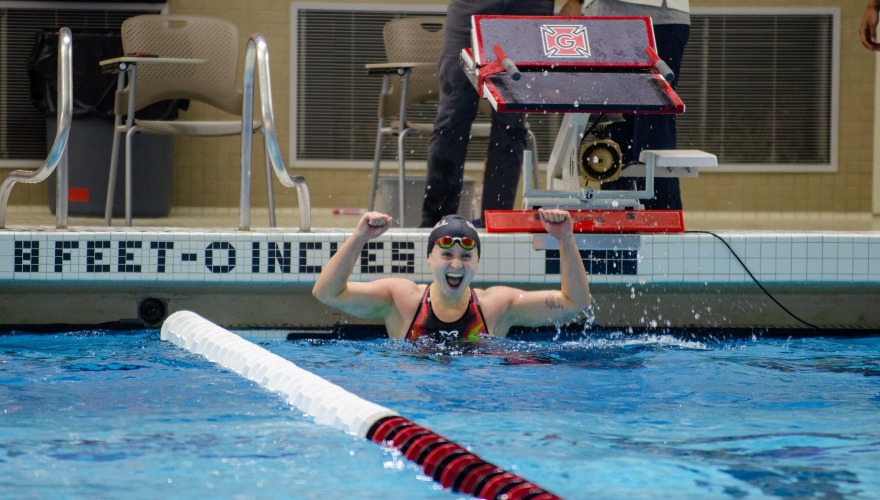 Women's swimmer celebrates in the pool after a race