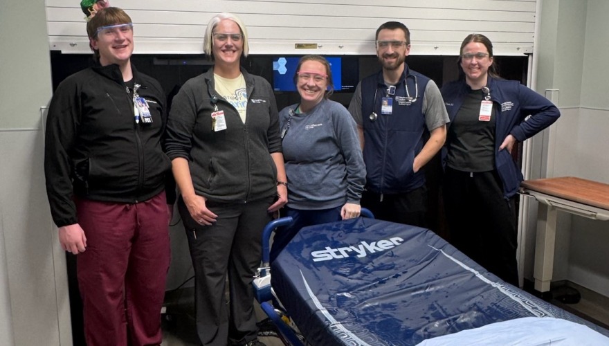 5 people standing in front of door at hospital 
