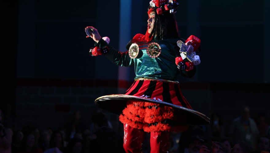 A performer on stage during Drag show lip syncs to a song.
