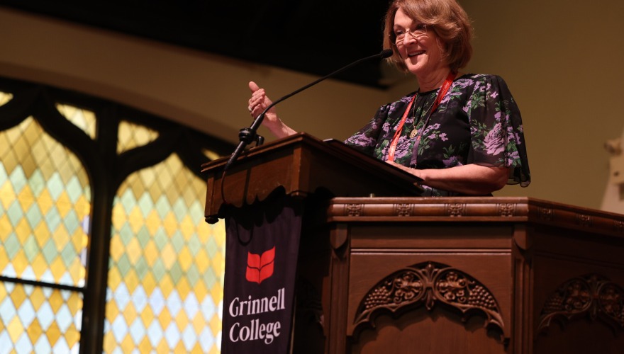 An alum gives a speech at the podium in Herrick Chapel after receiving an award during Alumni Assembly.