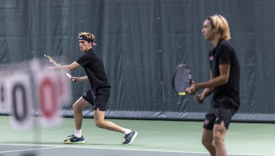 Two men’s tennis players waiting to receive the volley from their opponent.