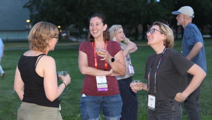 Three alums chat outside during a class year welcome party.