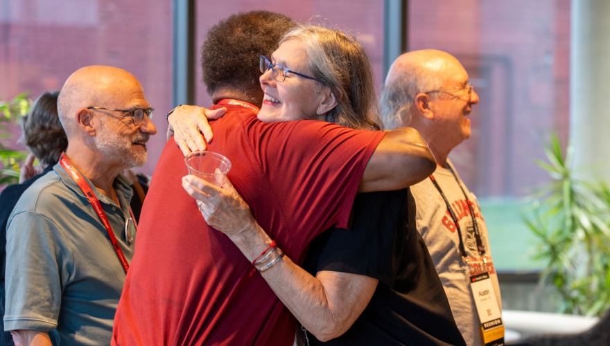 Two alums embrace at the Weingart Pavilion during a Reunion weekend welcome event.