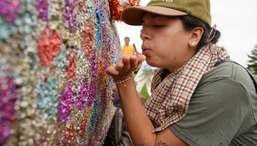 An alum blows glitter onto the side of the Glitter Truck during Alumni Reunion weekend.