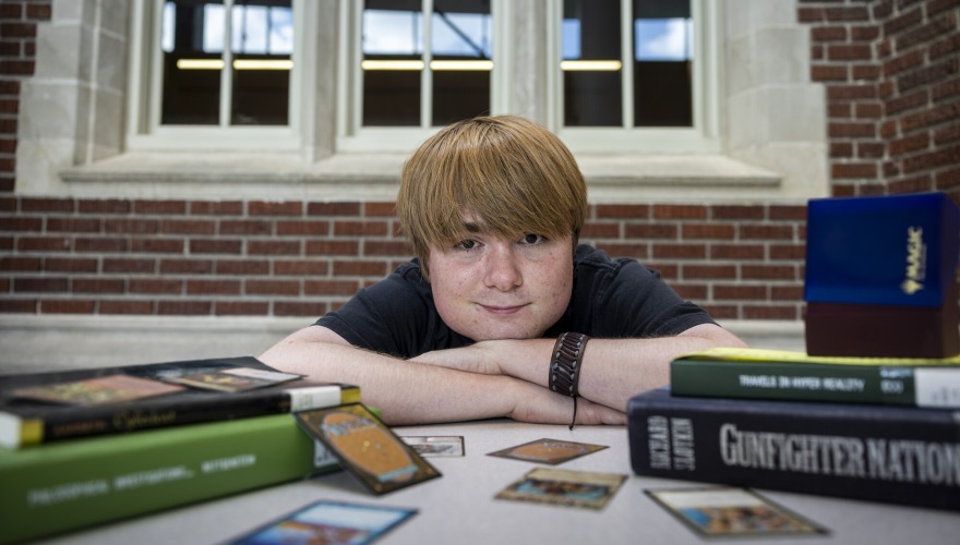 student with books and cards and laying on hands