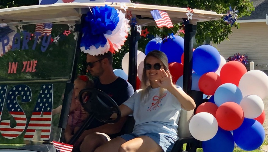 girl waving from decorated golf cart