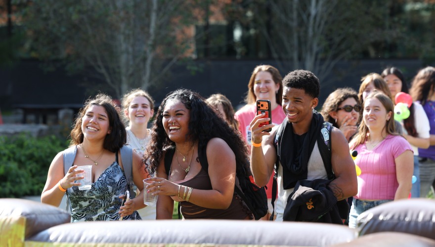 A group of students standing and laughing together.