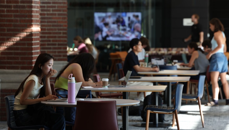 Students sitting at tables in the Humanities and Social Sciences Center.