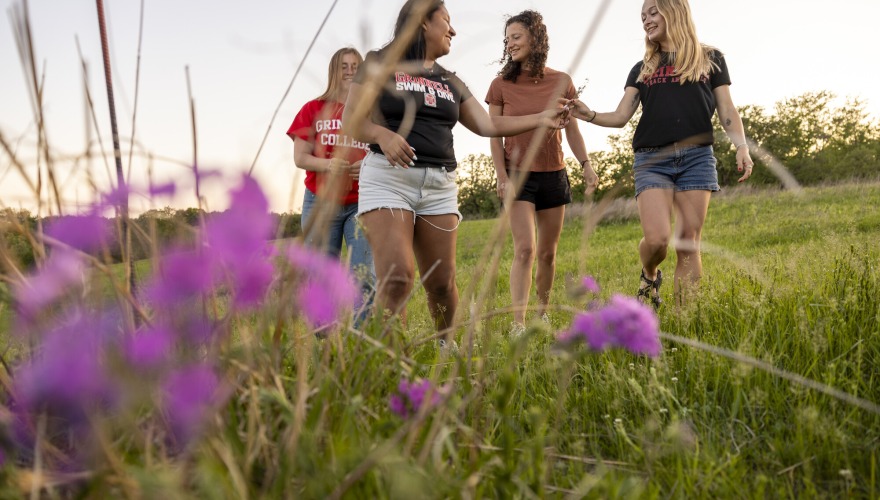 students in a field with purple flowers