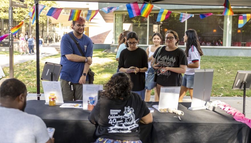 Students stand at information desk outside