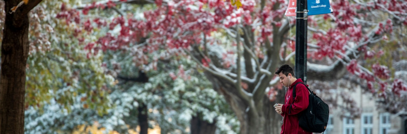 student walks on campus with light dusting of snow
