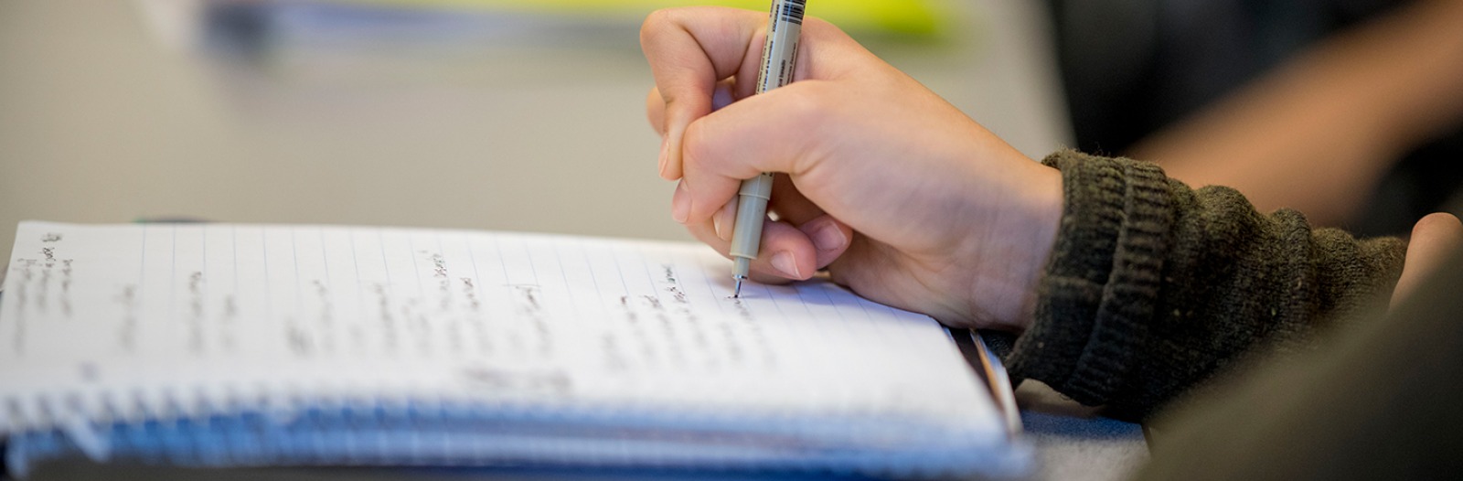 Close-up of a student writing in a notebook