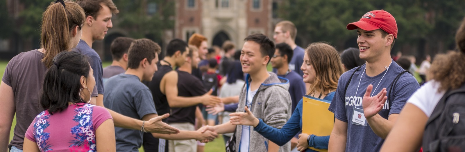 Students shaking hands in front of Gates Tower