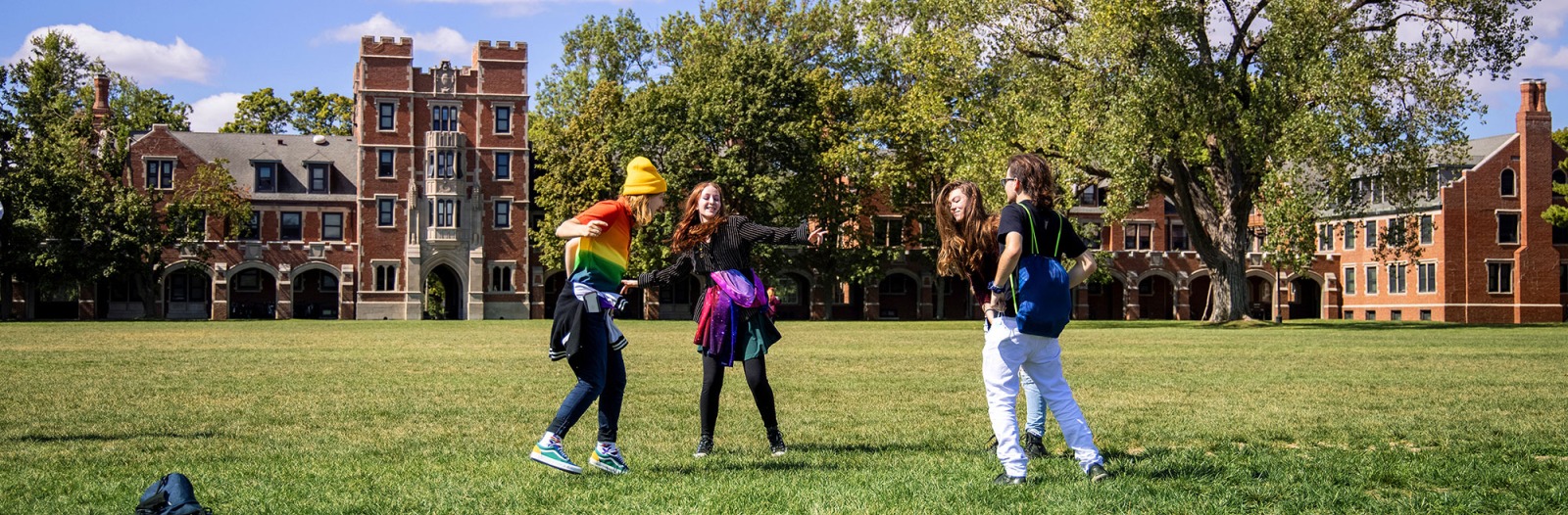 Four students dance on Mac Field