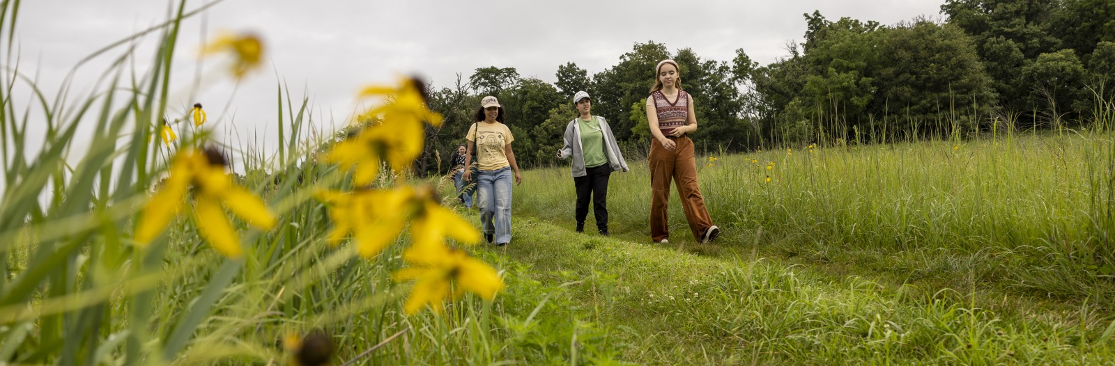 Bella Totten ’27 leading students to study site in the prairie of CERA
