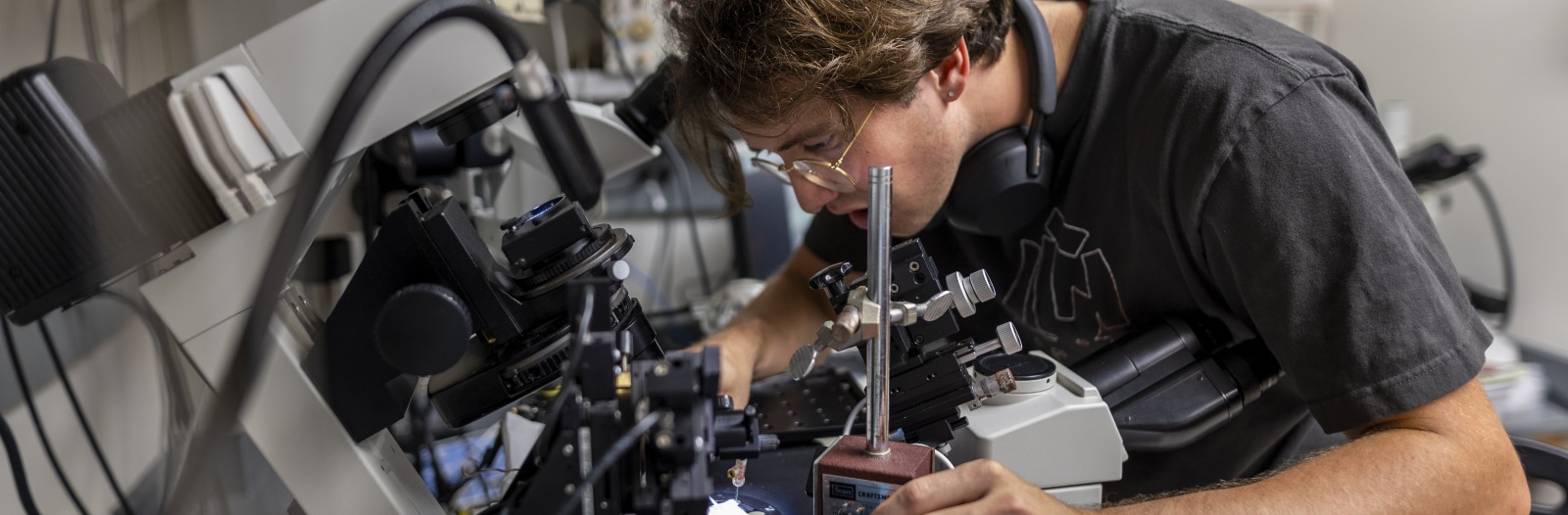 A young man manipulates equipment in a lab