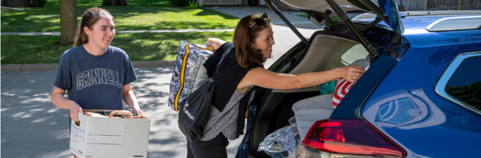 a student moves in to Grinnell and unloads items from her car