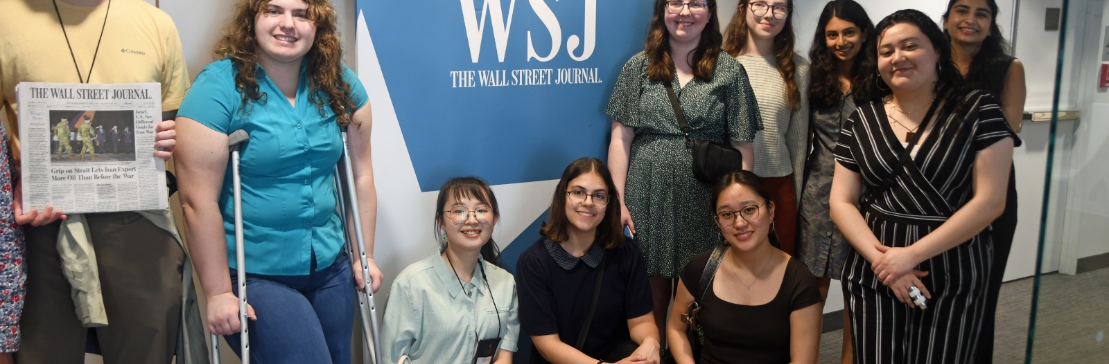 students near a wall street journal sign