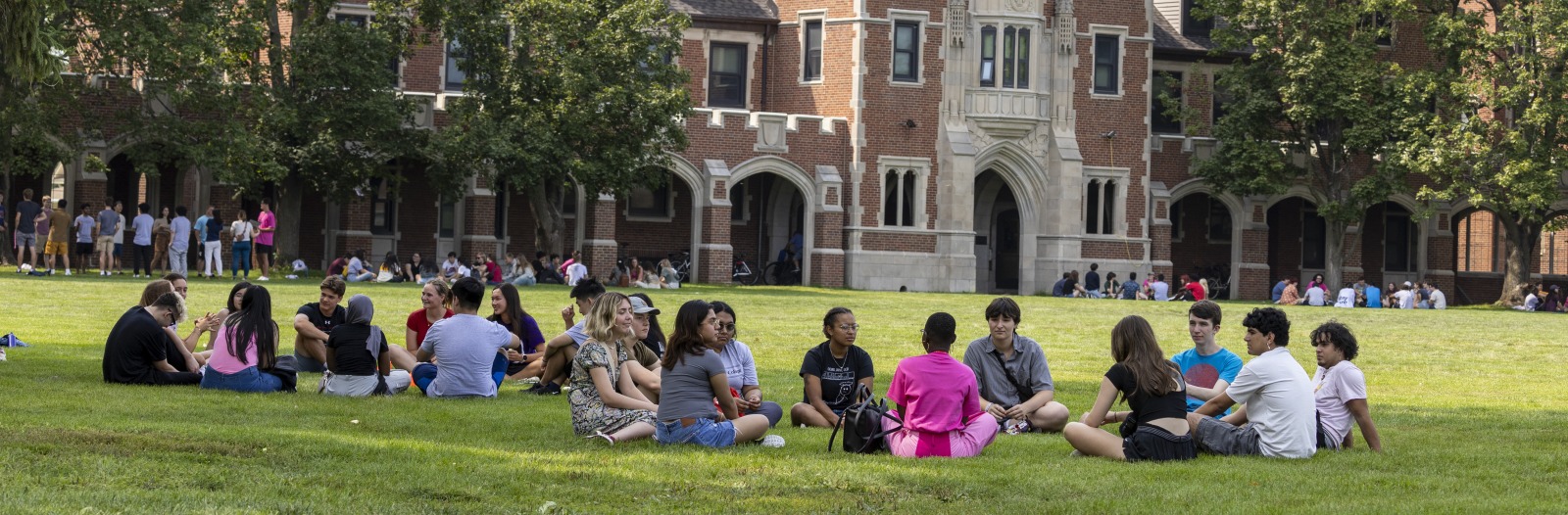 Large groups of students outside Gates Tower on sunny day