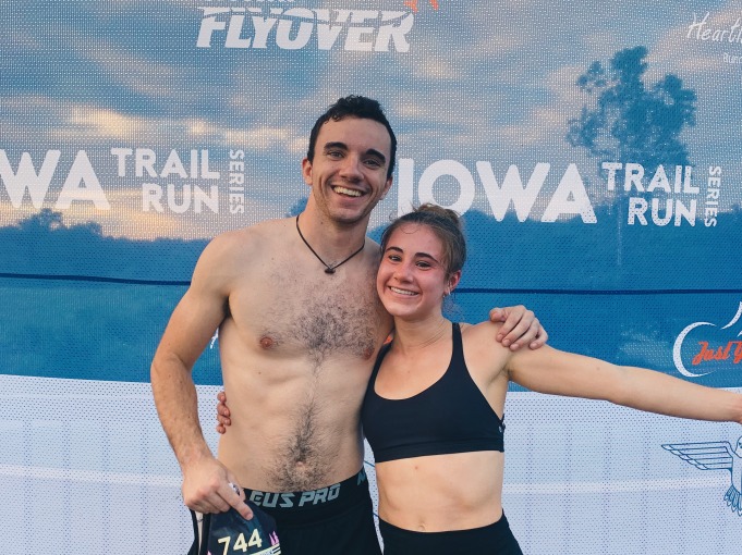 Picture of girl and guy in front of IOWA trail run wall