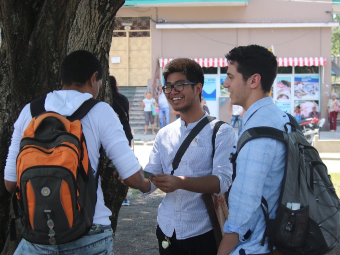 Three students in a group laughing together 
