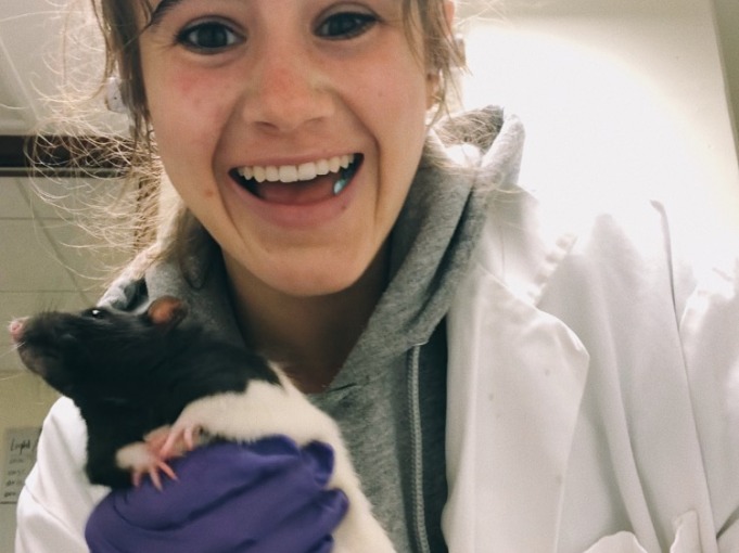 Girl holding lab rat.