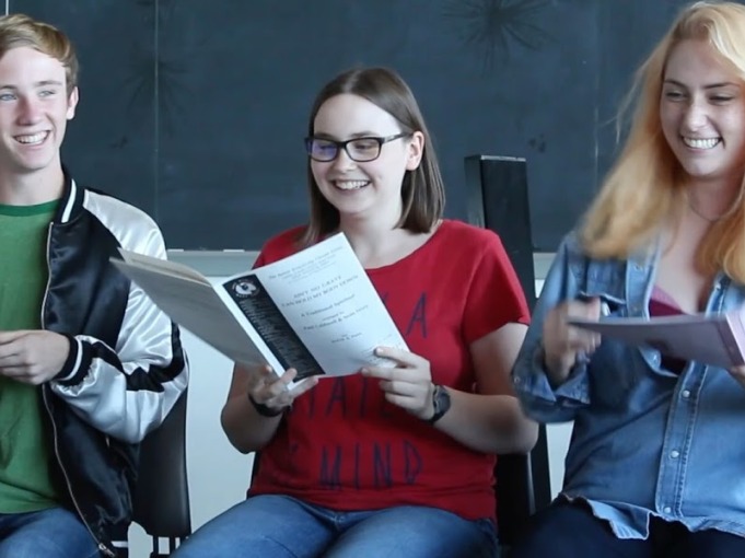 Three students looking through pamphlets 