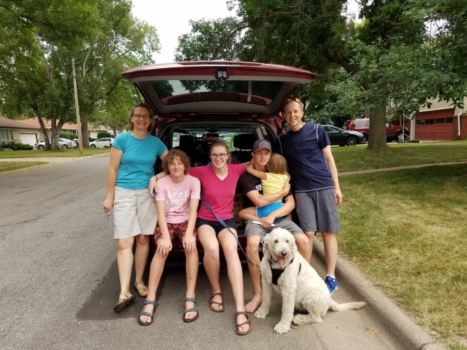 Ailsa with parents, siblings, and dog at back of vehicle