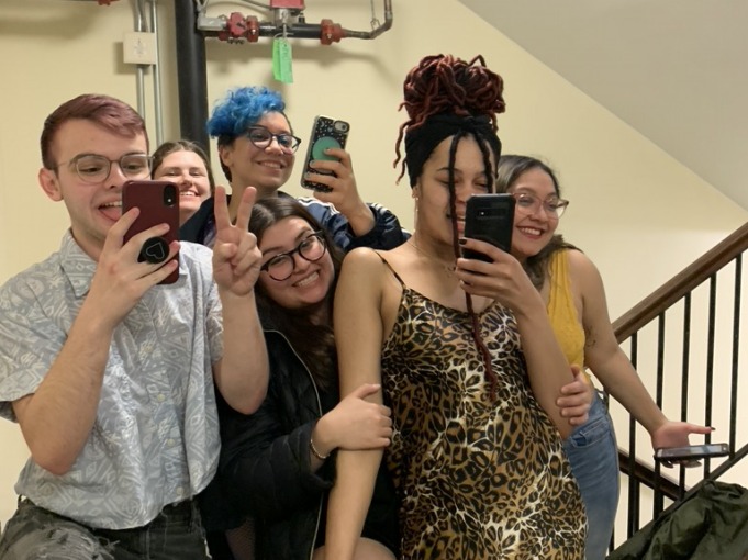 6 students dress for the party pose on interior stairs