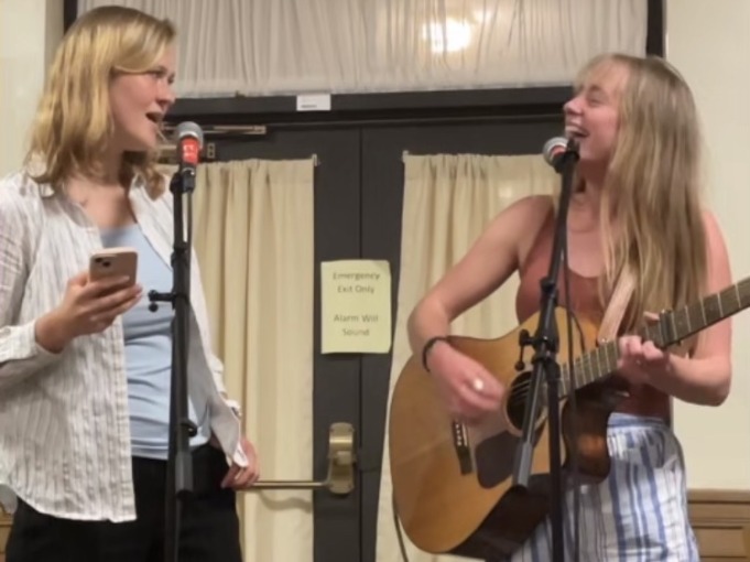 I sing and play guitar at an open-mic on campus with my friend Abbie. We sing together and look at each other with lots of joy