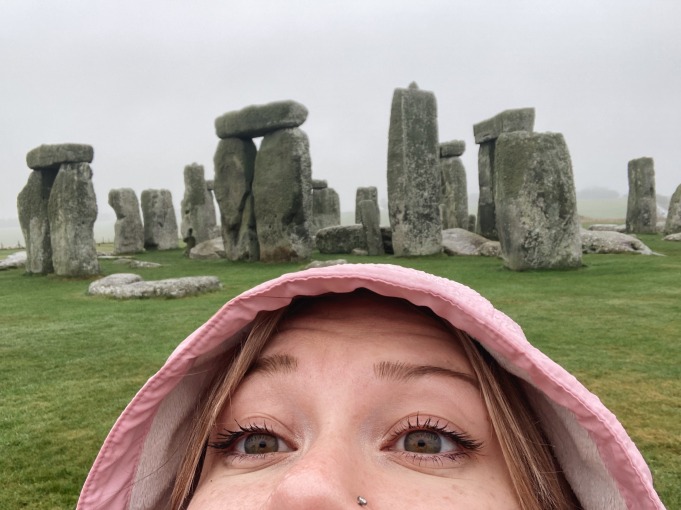 I take a selfie with top half part of my face showing and with Stonehenge rocks in the background.