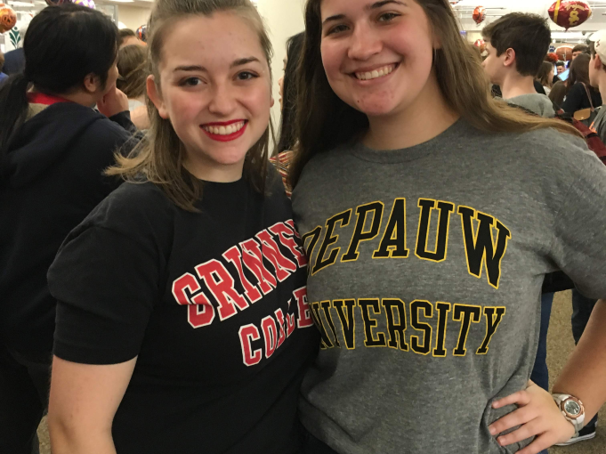 Sophie and their friend each wear their respective college gear: Sophie with Grinnell's and their friend with DePauw's.