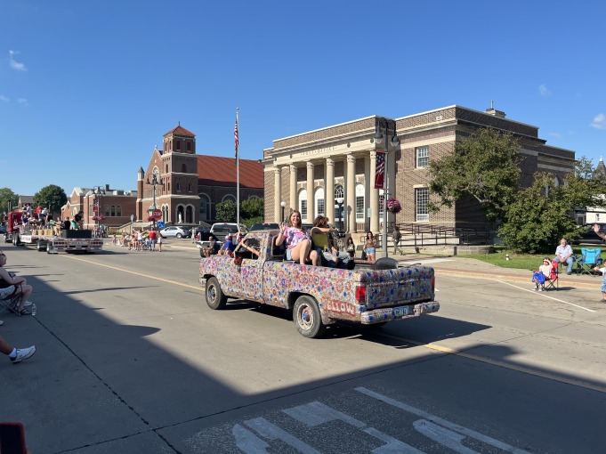 Greta sits on the truck bed of a well-decorated truck.
