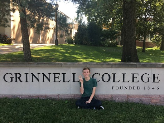 Student next to Grinnell college sign