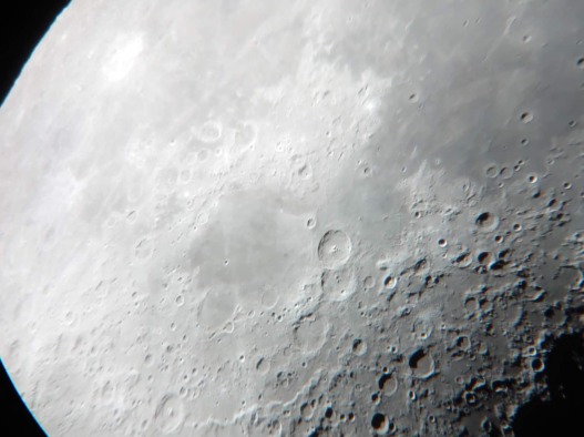 A shining moon seen through a telescope