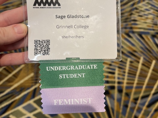 National Women’s Studies Association nametag of Sage Glastone, Grinnell College she/her/hers, undergraduate student and feminist.