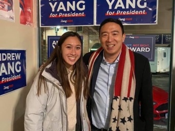 Man and Women in front of Andrew Yang signs 