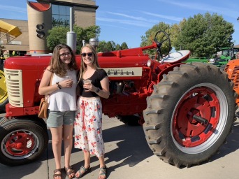 Two students in front of read tractor 