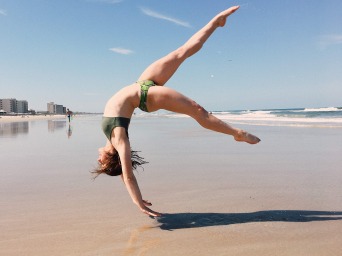 Girl doing flip on beach