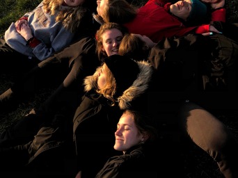 Girls group photo lying on grass