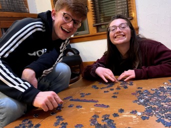 My friends sitting near a table with a puzzle