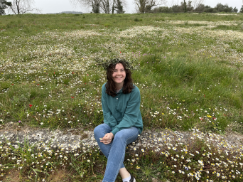 Me sitting near the flowers and grass at the site of the Ancient Olympic Games