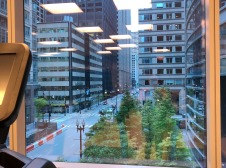 downtown street with trees viewed from a gym window
