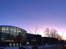 Noyce Science Center on a snowy winter evening with the glow of the setting sun to the west