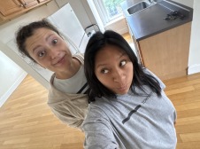 Maria and Eleanor excitedly take a selfie in an empty kitchen.