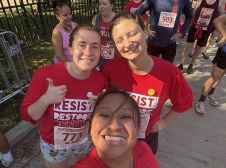 Maria, Eleanor, and a mutual friend take a picture together. They wear a "Resist, Restore" red t-shirt.